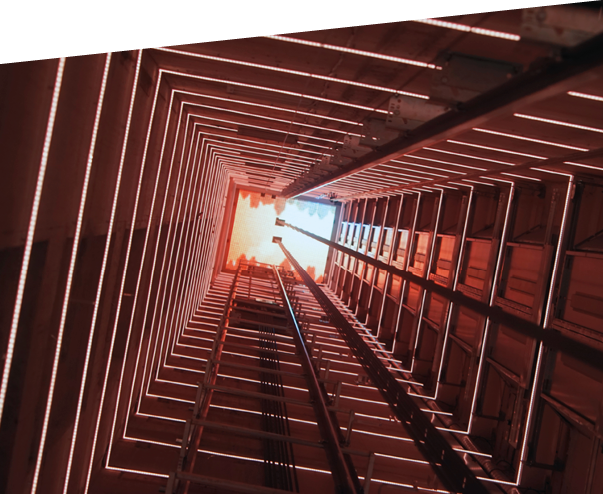 Elevator corridor in the building lit by red elumination  Futuristic elevator shaft is located in a high tower  Lift shaft in a residential building  Abstract, background  Bottom view 