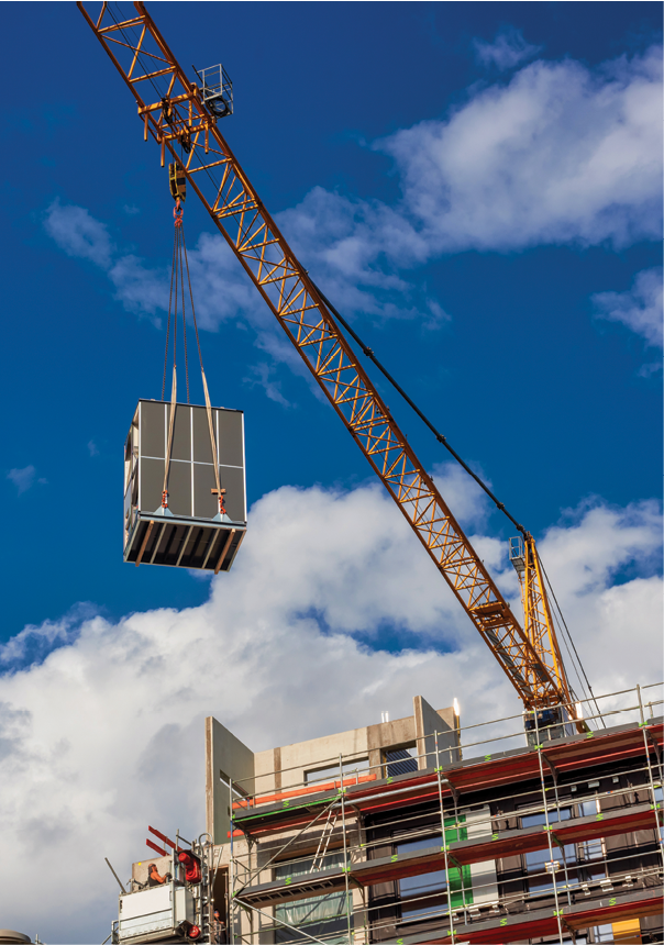 A Crane is lifting a building module to its position in the structure  Construction site of a new modular timber construction office building  